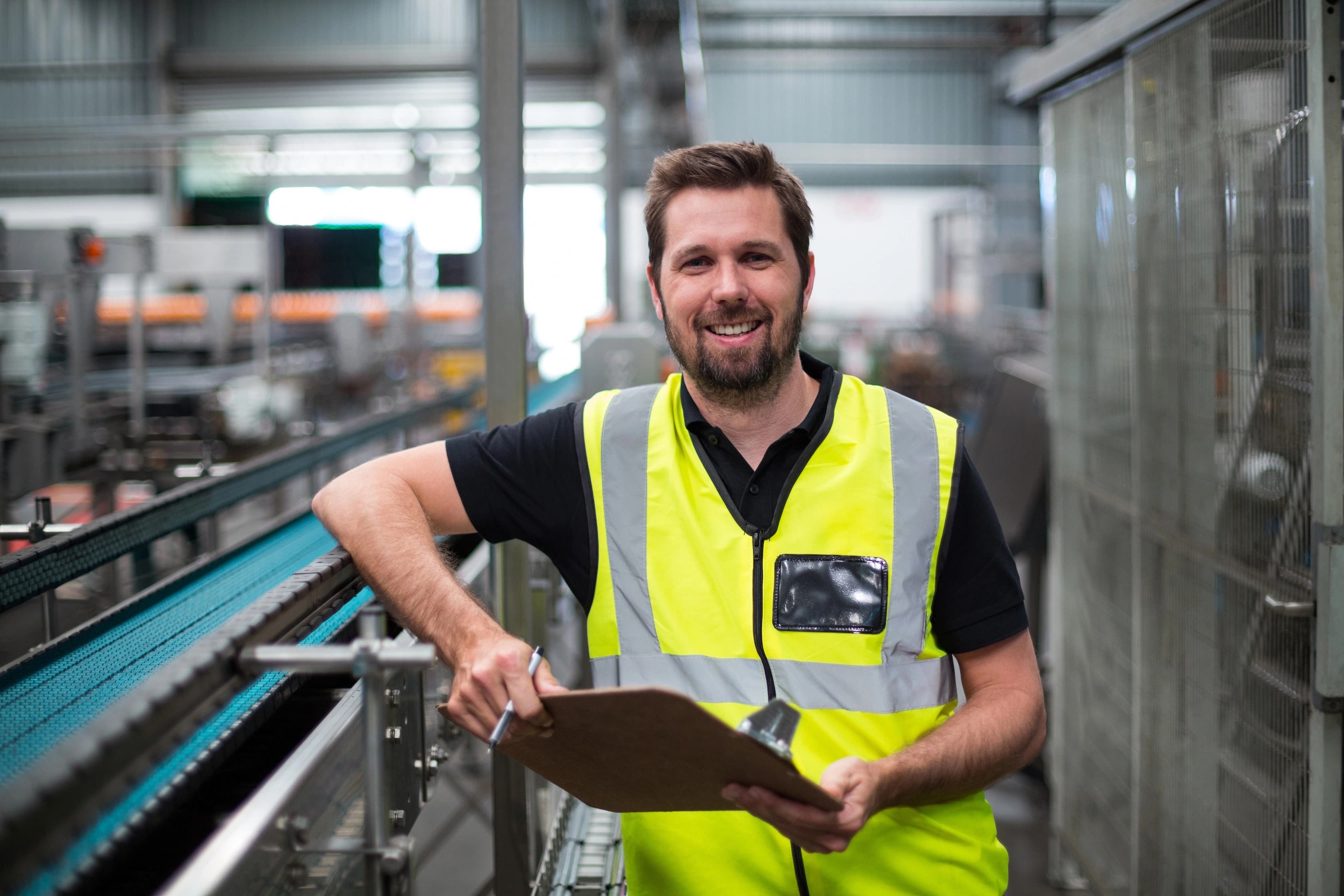 Man in hesje glimlacht naar de camera